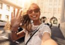 Young woman taking selfie in a street. Tourist posing for a selfie in a street. Vlogger recording content for her travel vlog.